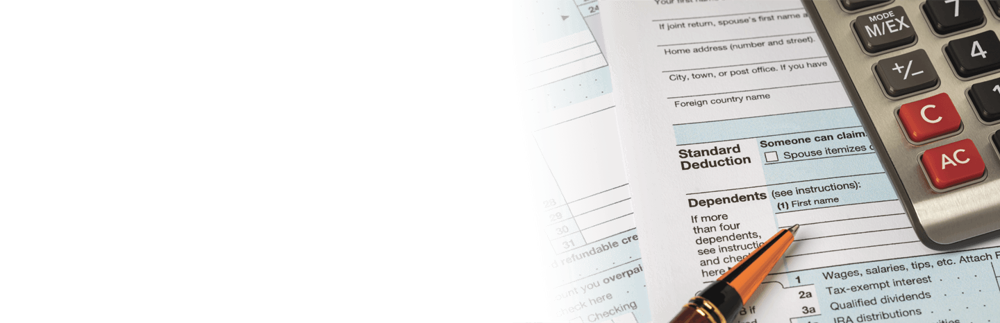 Image of tax forms with a pen and calculator