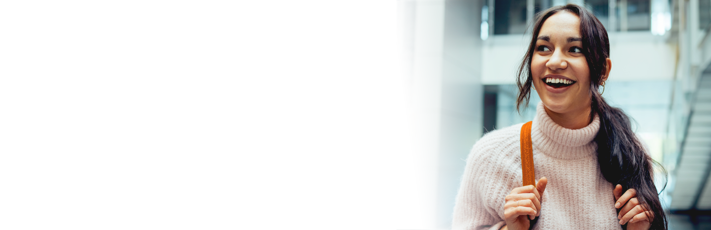 Happy female student going for class. Young woman smiling in college campus.