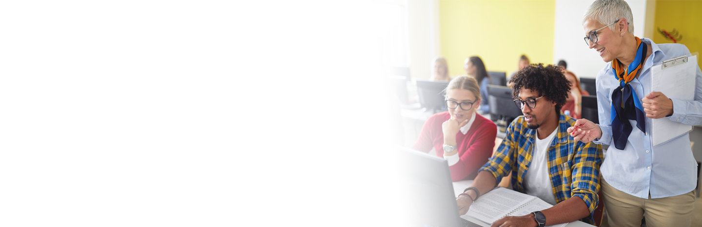 Female professor helping students working on a laptop in class